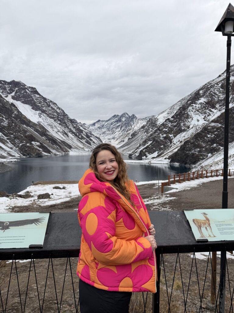 Mulher em frente à Laguna del Inca, em Portillo, no Chile, com as montanhas nevadas ao fundo