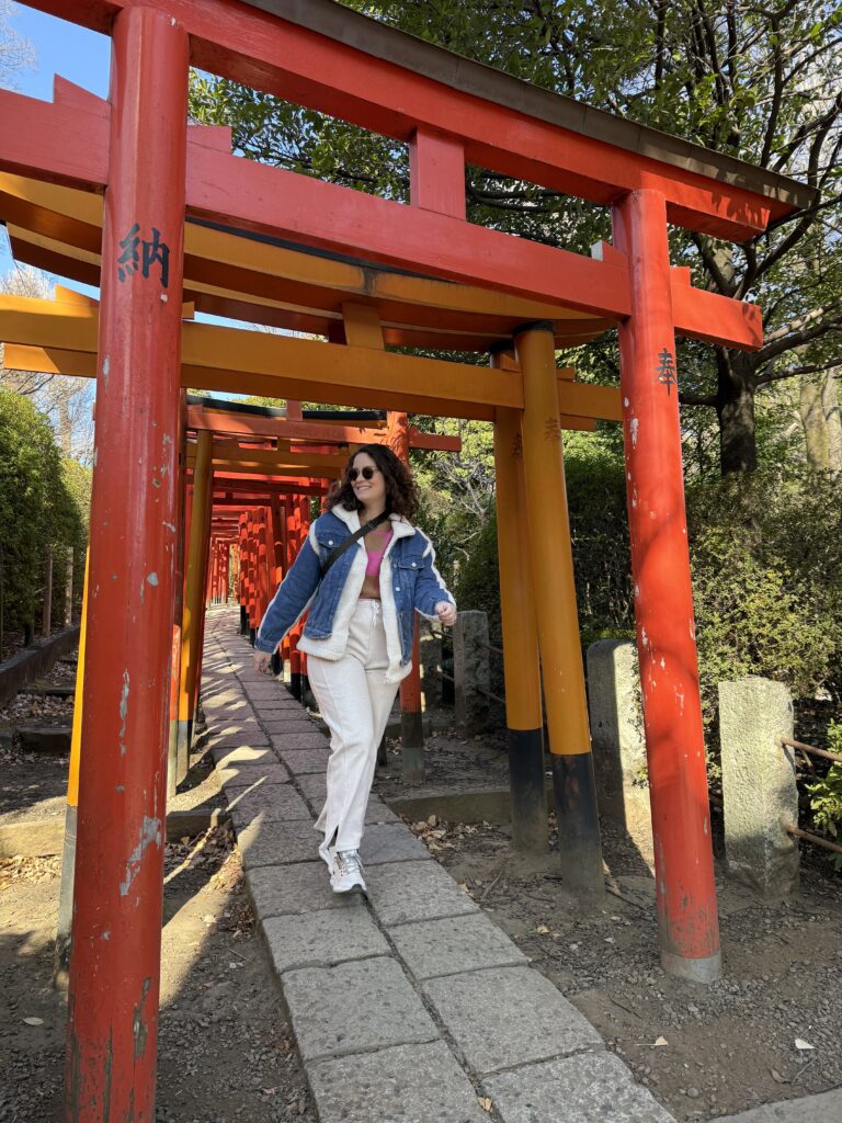 Mulher caminhando sob os portões torii laranja da trilha do Fushimi Inari, em Kyoto