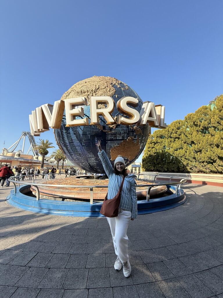 Mulher de braços abertos em frente ao globo giratório do Universal Studios Japan, em Osaka