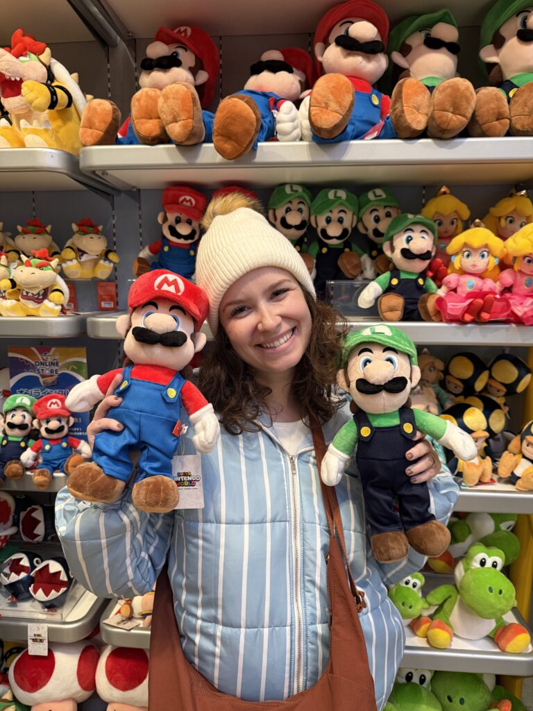 Mulher segurando pelúcias do Mario e do Luigi na loja do Super Nintendo World, no Universal Studios Japan