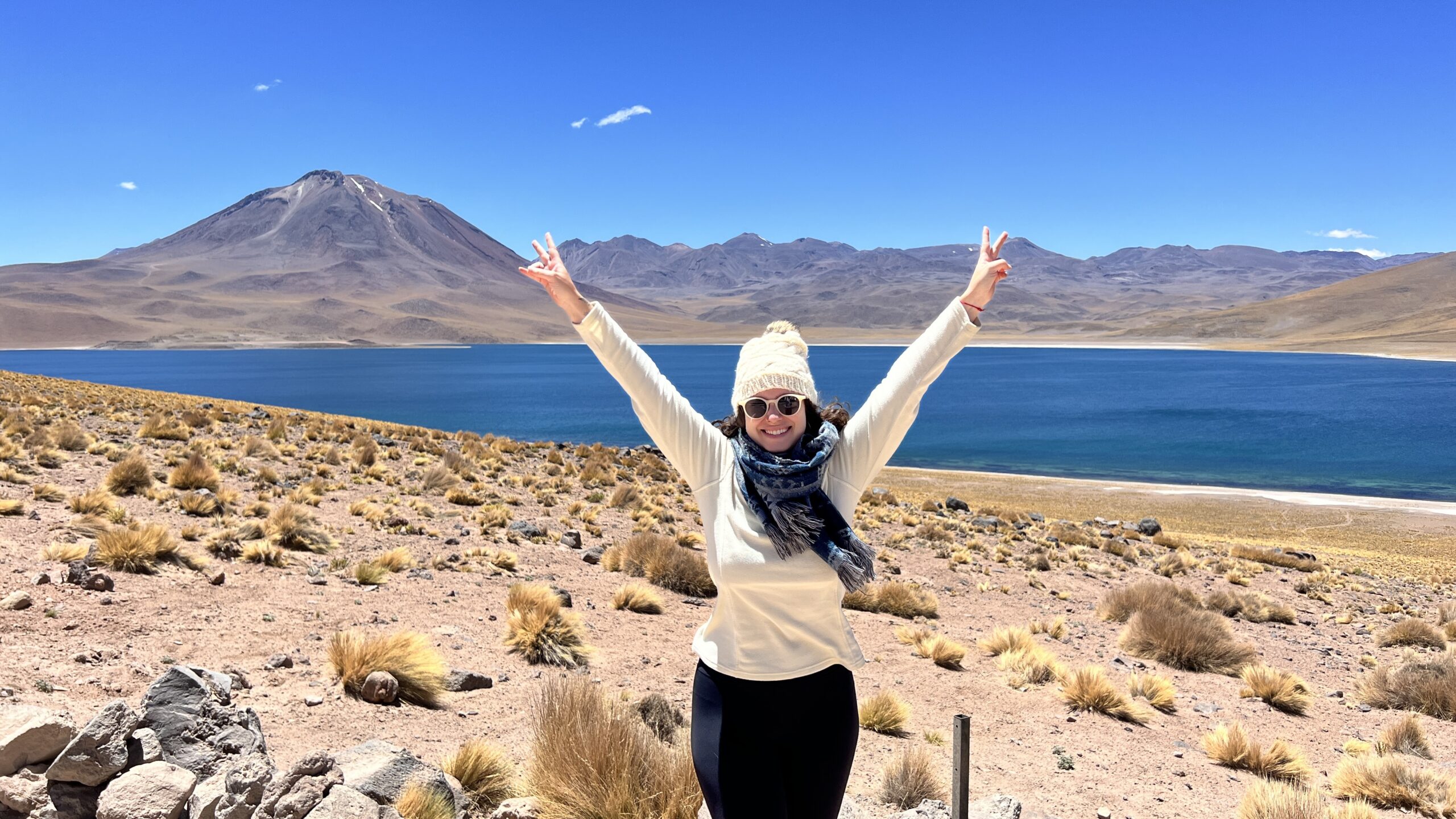 Mulher de bracos abertos diante da Laguna Miscanti, nas Lagunas Altiplanicas do deserto do Atacama, Chile