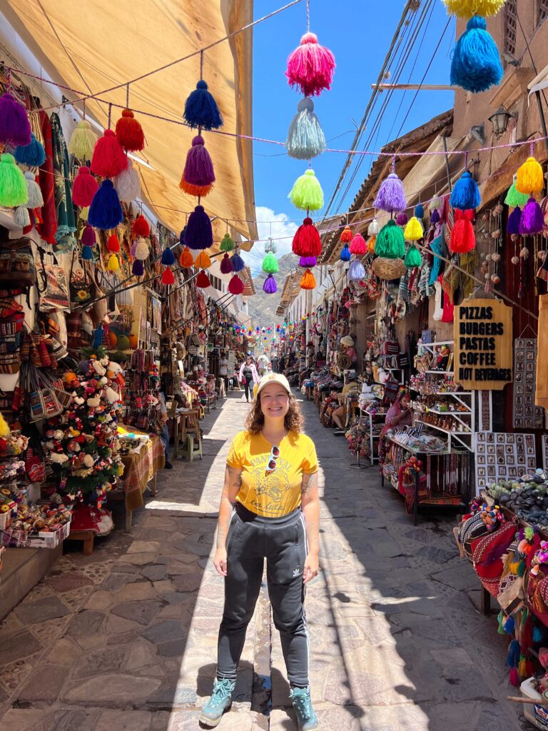 Rua do mercado de artesanato de Pisac decorada com pompons coloridos de lã, no Vale Sagrado do Peru