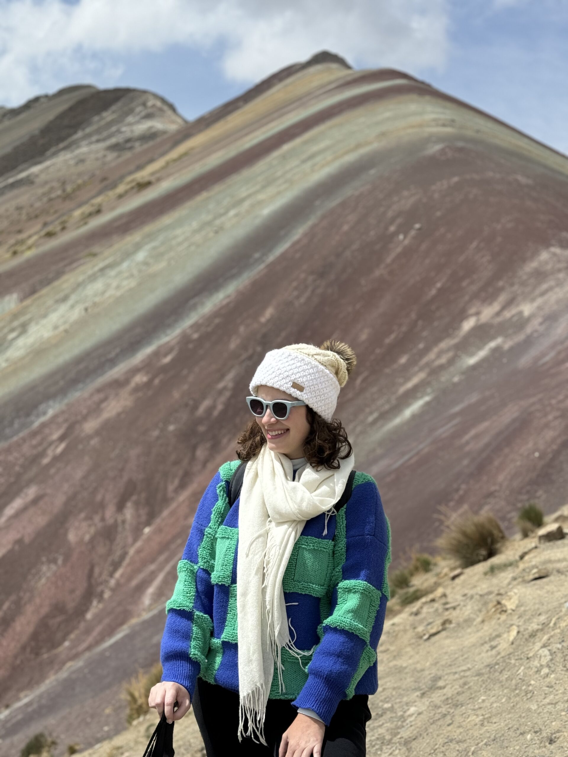 Viajante em frente às faixas coloridas da Montanha Colorida (Vinicunca), a 5.200 m de altitude no Peru