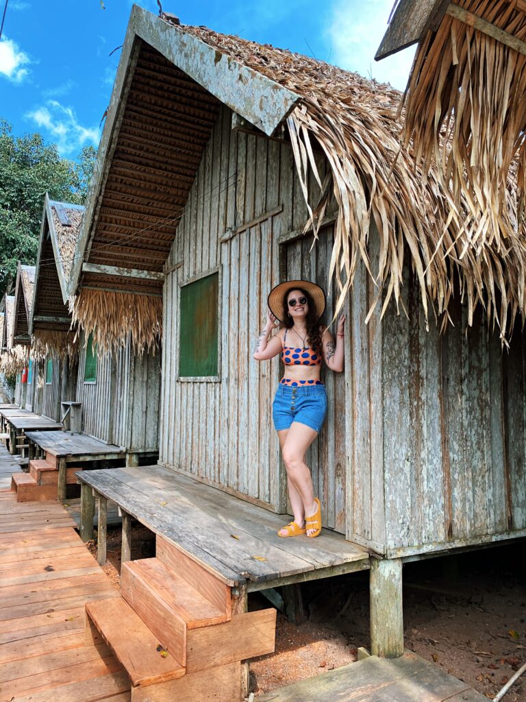 Cabana simples de madeira com telhado de palha em hotel de selva na Amazônia