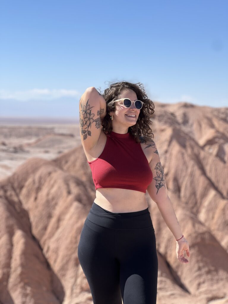 Mulher em pé diante das formações vermelhas do Valle de la Luna, Atacama