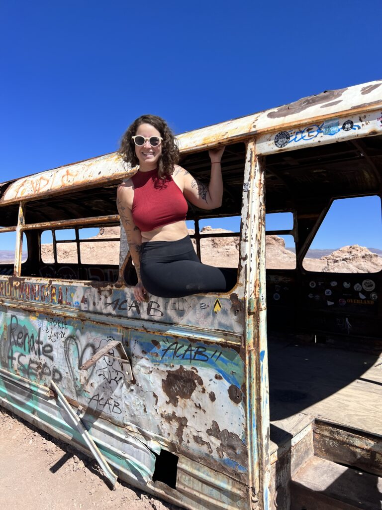 Mulher dentro de ônibus abandonado no deserto do Atacama
