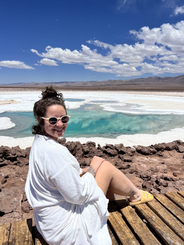 Mulher de roupão sentada no deck da Laguna Cejar depois do banho, Atacama
