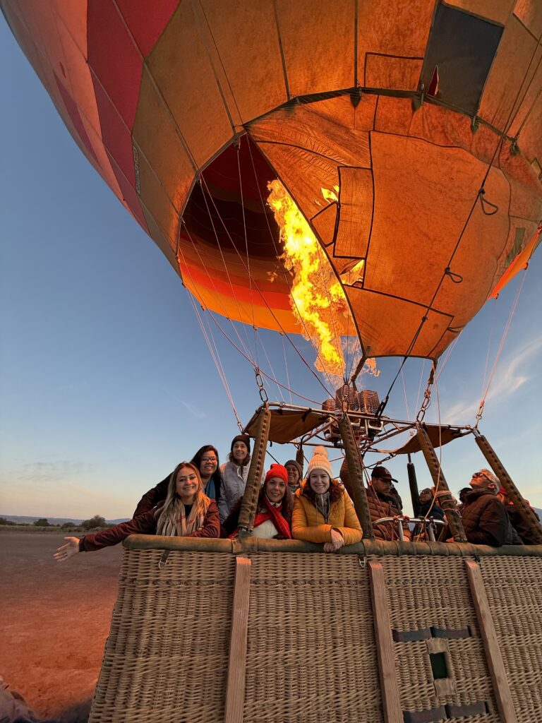 Queimador aceso e passageiros no cesto do balão ao amanhecer no deserto do Atacama