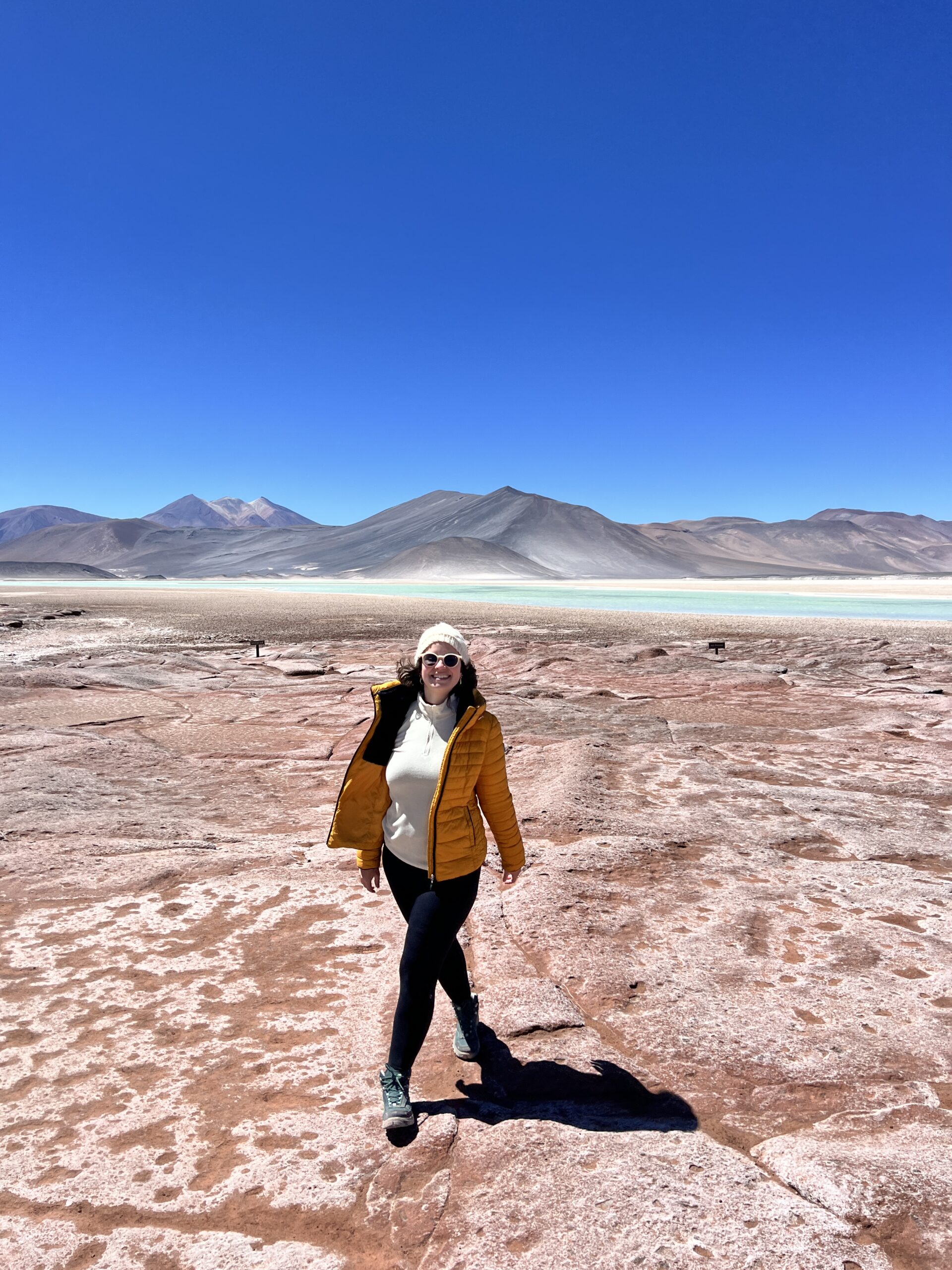 Mulher em pé sobre o solo avermelhado das Piedras Rojas, Atacama, Chile