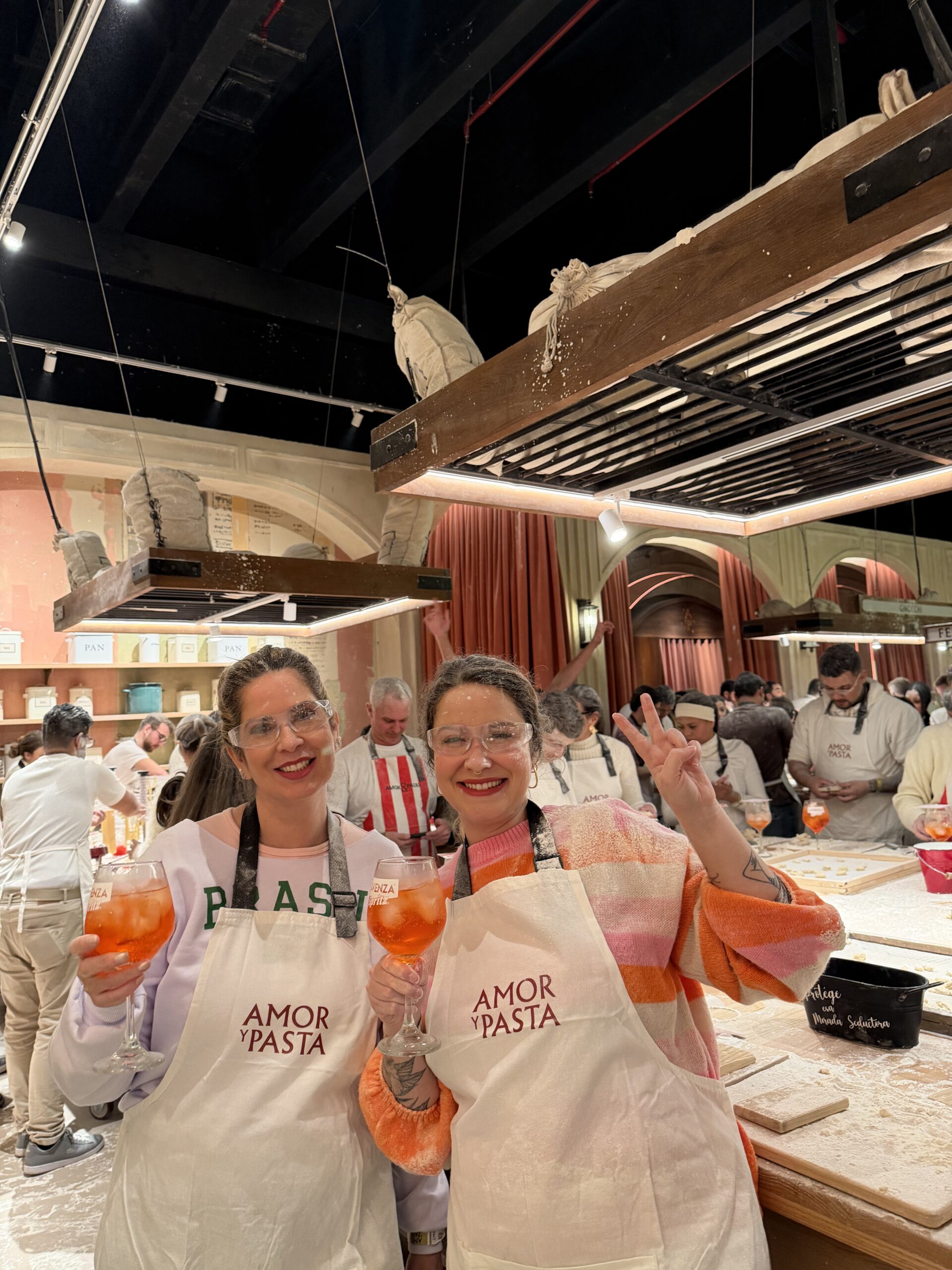 Grupo de participantes com aventais na aula de massas do Amor y Pasta, em Santiago do Chile