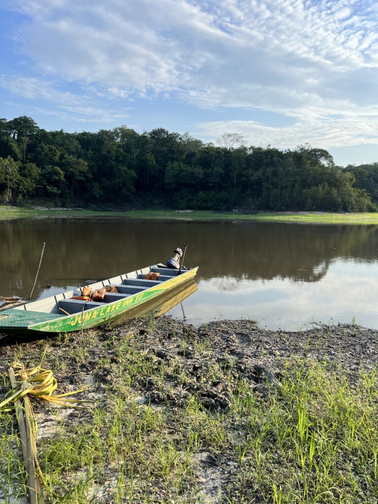 Barco encostado em margem de areia com o rio baixo, na Amazônia