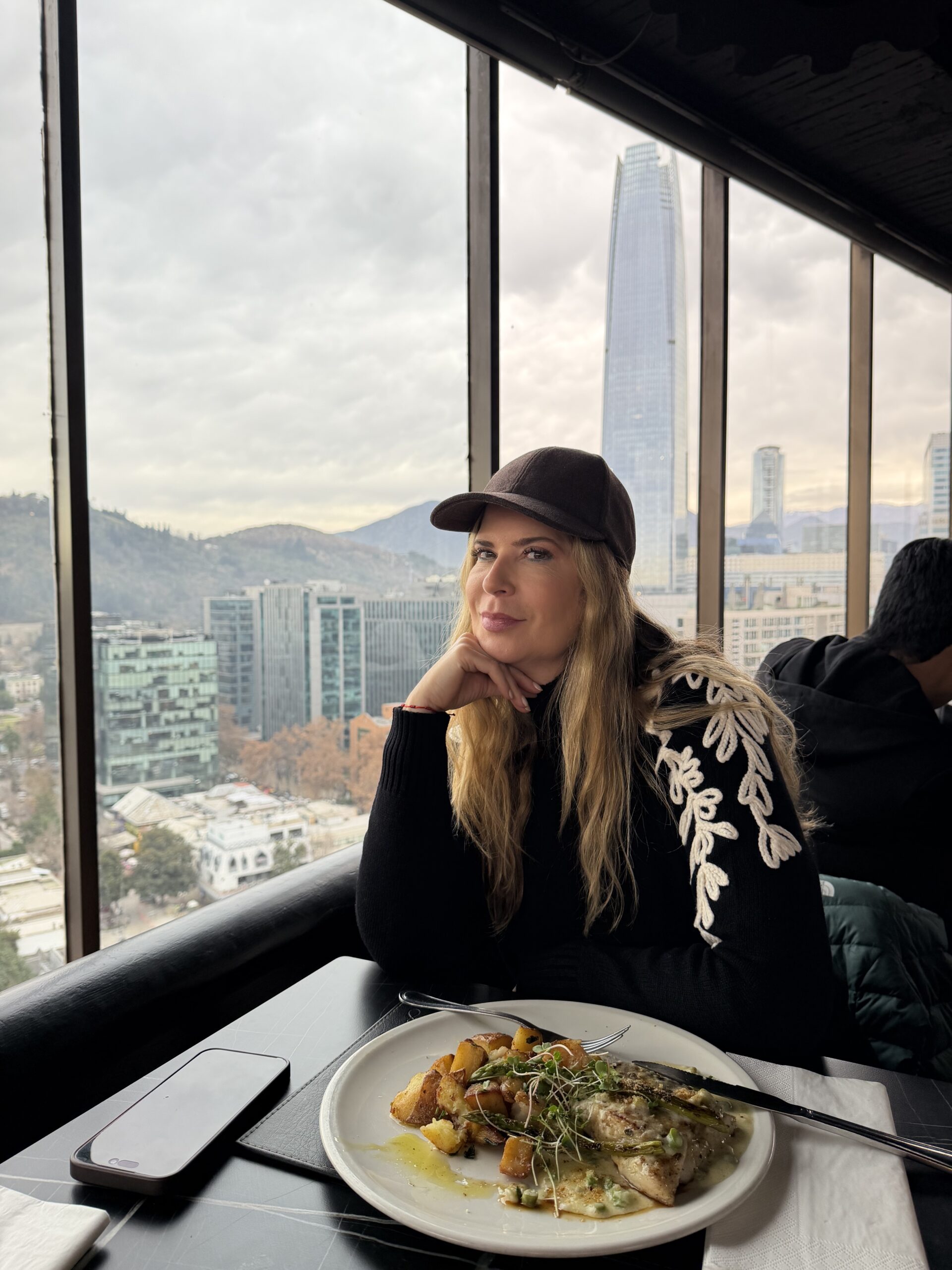Mesa junto à janela no restaurante Giratorio, em Santiago do Chile, com vista para a cidade e a cordilheira
