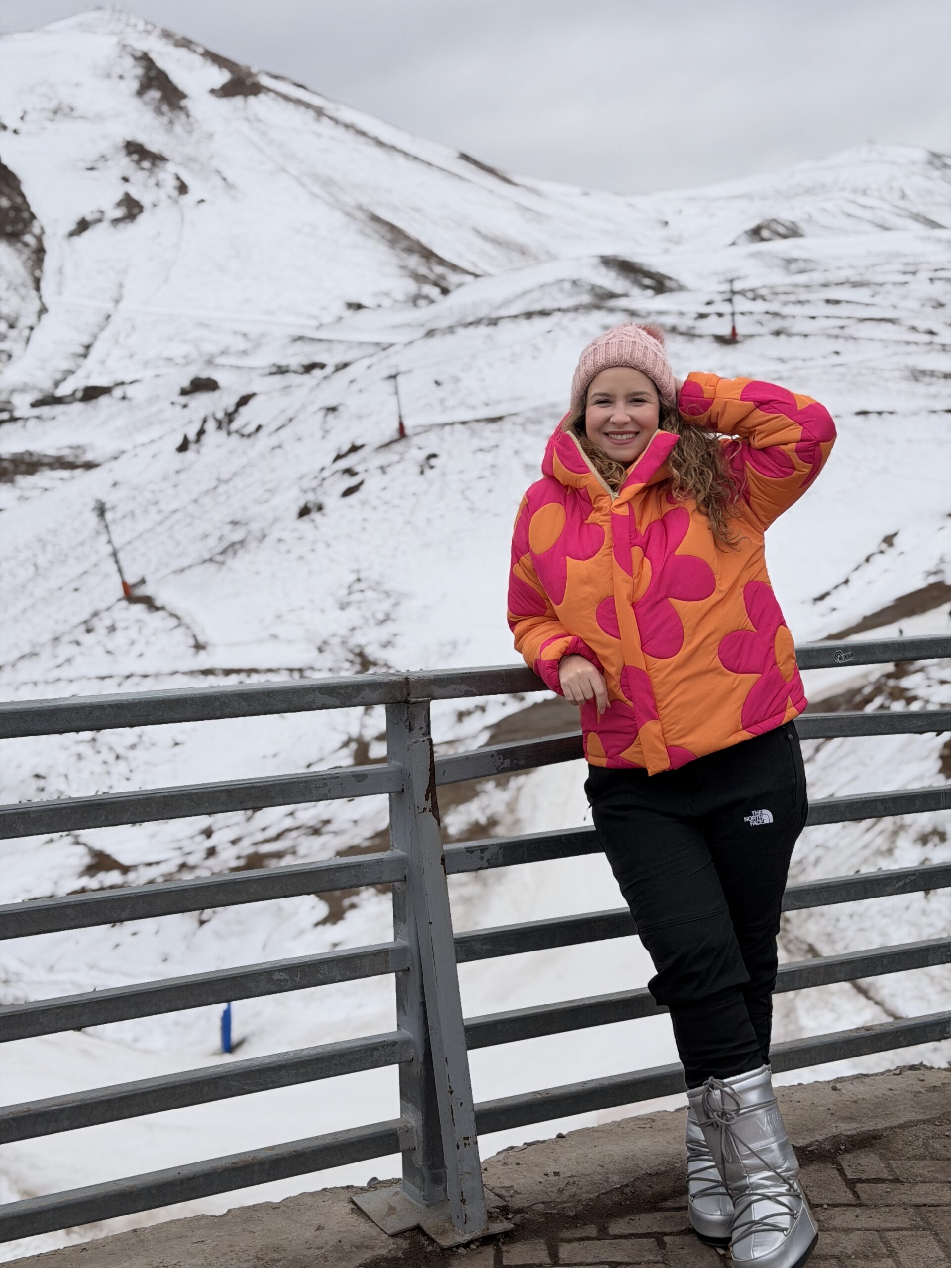Mulher vestida com casaco e calça de neve no Valle Nevado, no Chile, mostrando a roupa de inverno alugada